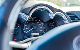 Detailed view of a car's speedometer and gauges from the driver's seat, highlighting instrument clarity.