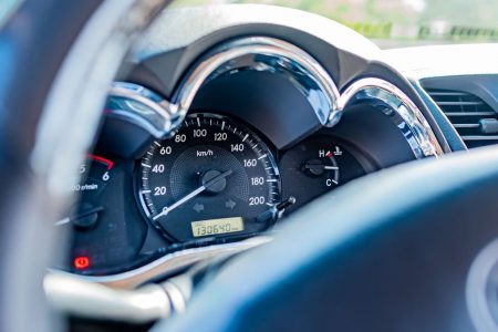 Detailed view of a car's speedometer and gauges from the driver's seat, highlighting instrument clarity.
