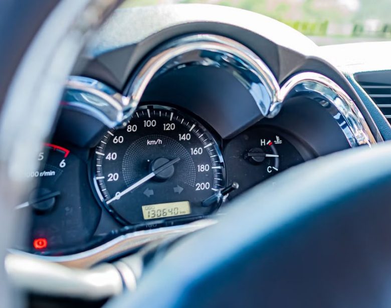 Detailed view of a car's speedometer and gauges from the driver's seat, highlighting instrument clarity.