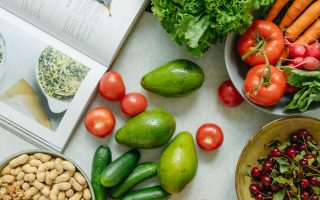 An appetizing display of fresh fruits and vegetables with a cookbook, perfect for healthy recipes.
